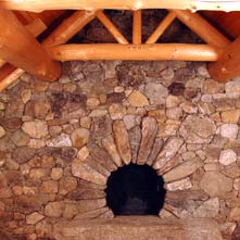 Sunburst New England fieldstone fireplace with floating antique granite hearth