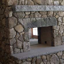 Pass-through fieldstone fireplace with antique granite lintel and Swenson gray granite mantel & hearth